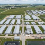 Farrow-to-finish pig farm aerial view showing farrowing nursery and grow-finish barns, USA, 2026